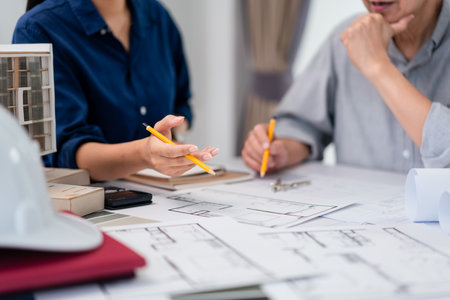 Two architects are discussion and analysis about construction of building project on blueprint.の写真素材