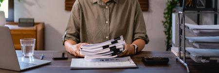 Casual business women stacking business document after examine financial data of project in office.の写真素材