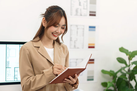 Architecture concept, Female architect write planning data of designing house interior in notebook.