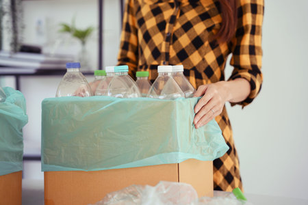 Women holding cardboard box of plastic bottle to reuse and recycling for sustainable environment.
