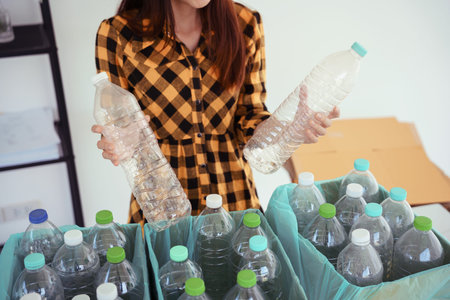 Women holding plastic bottle and putting in box to reuse and recycling for sustainable environment.の写真素材
