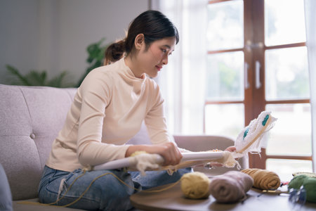 Young asian woman holding embroidery fabric frame with punch needle technique in hobby lifestyle.の写真素材
