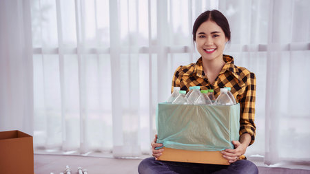 Women holding box containing sorting plastic bottle to reuse and recycling for saving environment.の写真素材
