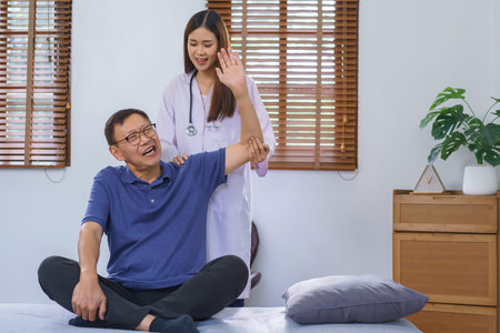 Healthcare concept, Senior man painful while doing physiotherapy and stretching by woman caregiver.