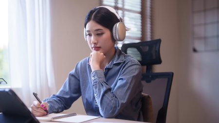 Young asian student women wearing headphone to learning lecture webinar in online class on tablet...