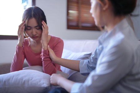 Asian psychologist women touching to encouraging patient and giving counseling about medicine and mental health therapy while female patient stressed and headache with psychological health problem.の写真素材