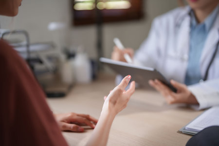 Asian patient women with anxiety explaining about psychological health problem to doctor while female psychologist writing notes on tablet and counseling about medicine and mental health therapy.の写真素材