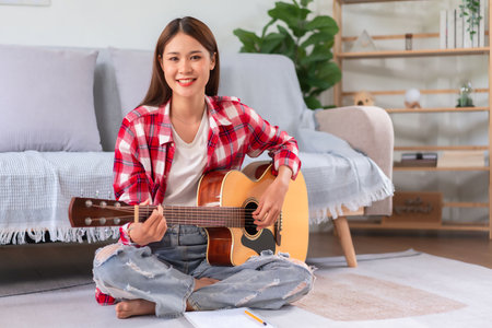 Concept of relaxation with music, Young woman playing acoustic guitar after composing new song.の写真素材