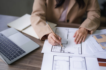Female architect work to designing interior building and drawing construction project on blueprint.の写真素材