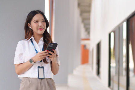 Young Asian businesswoman using her smartphone for work communicationの写真素材