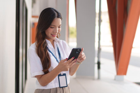 Confident young Asian businesswoman checking her smartphoneの写真素材