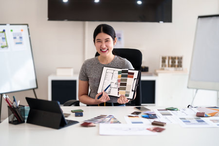 Young architect presenting interior design ideas through tablet during online meeting in creative officeの写真素材
