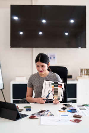 Young architect presenting interior design ideas through tablet during online meeting in creative officeの写真素材
