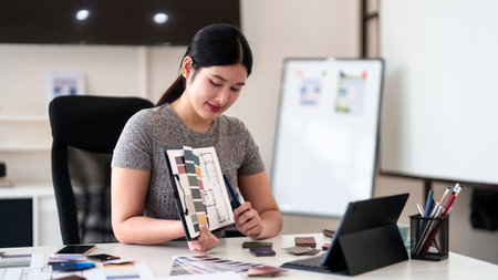 Young architect presenting interior design ideas through tablet during online meeting in creative officeの写真素材