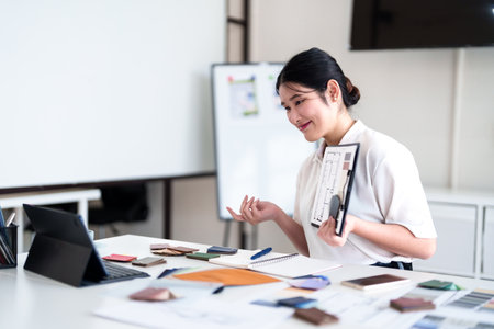 Young architect presenting interior design ideas through laptop during online meeting in creative officeの写真素材