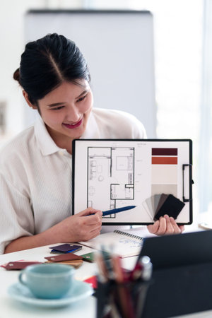 Young architect presenting interior design ideas through laptop during online meeting in creative...