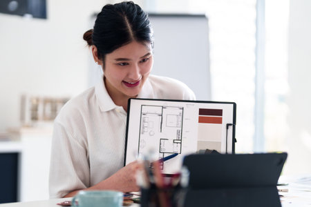 Young architect presenting interior design ideas through laptop during online meeting in creative officeの写真素材