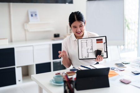 Young architect presenting interior design ideas through laptop during online meeting in creative officeの写真素材