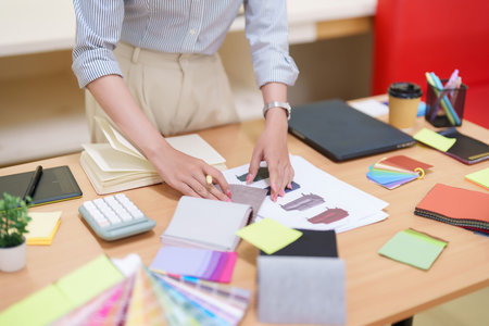 Asian women interior designer working on a home renovation project, selecting fabric samples....