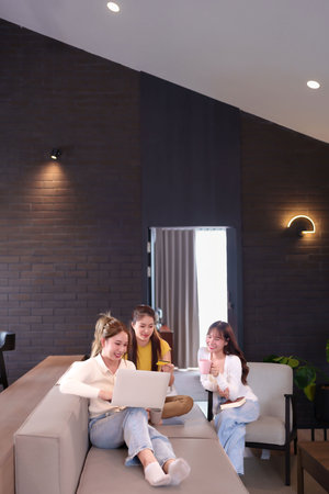 Group of Asian women enjoy easy online shopping using laptop and credit card at home They look happy and excited for the purchase or discount Modern lifestyles with happy friendsの写真素材