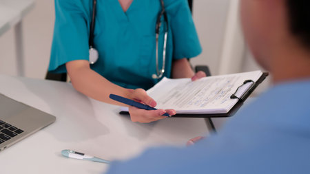 An Asian adult female doctor is consulting with her patient in clinic. Healthcare professional explaining medical report for examination checkup providing healthcare treatment.の写真素材