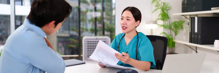 Asian woman doctor in clinic explaining medical report to her patient healthcare checkup in examination room diagnostic consultation for treatment and medical careの写真素材