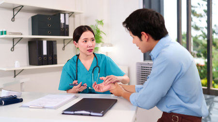 Asian women doctor checkup wrist of adult patient and holding pen for treatment in examination room. Doctor consultation about physical checkup for health at clinic or hospital.の写真素材