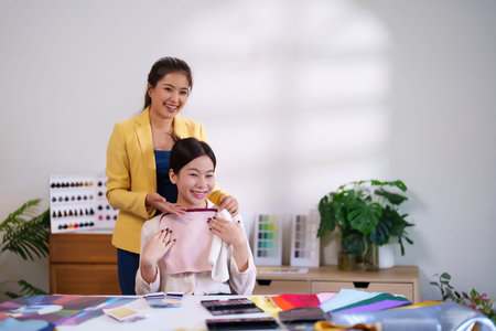 Adult Asian women are consulting about personal color analysis to choose clothing colors matching skin tone for best look. It is a fashion and beauty concept.の写真素材