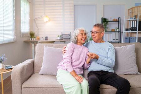 Loving older Asian couple spending quality time at home embracing their golden years This serene shot captures their deep connection and the joy of shared moments togetherの写真素材