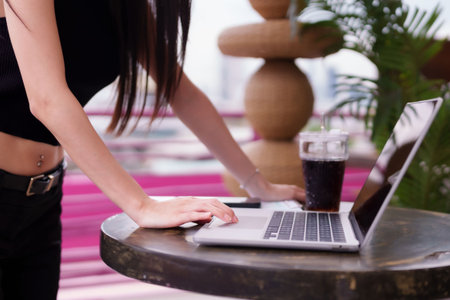 Confident Asian adult woman engaging with laptop. Professional remote work in a modern urban environment. Dynamic business lifestyle.の写真素材