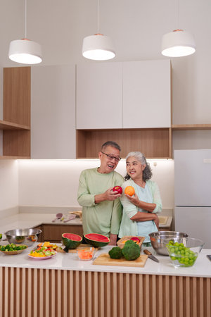 Older Asian man woman prepare vibrant delicious meal Kitchen filled healthy colorful produce Joyful domestic scene Lifestyle wellnessの写真素材