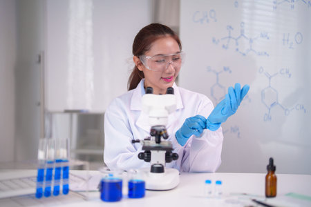 Dedicated Asian scientist prepares for an important chemistry experiment. She wears safety eyewear...