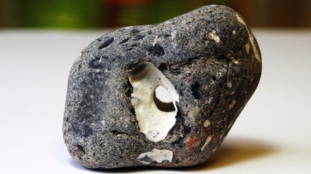 Stone with hole Flint black knows breakthroughの写真素材
