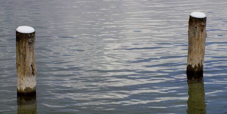 two wooden posts in Starnberg Lake in winterの写真素材