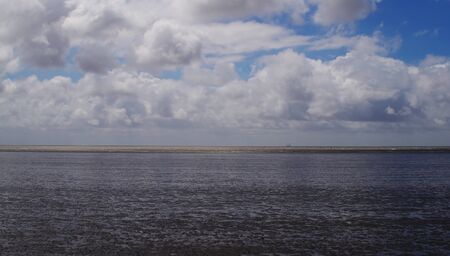 Clouds in the sky above the watt at the North Seaの写真素材