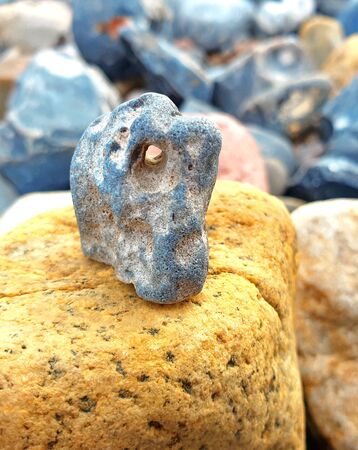 Flint with a hole on a yellow rockの写真素材