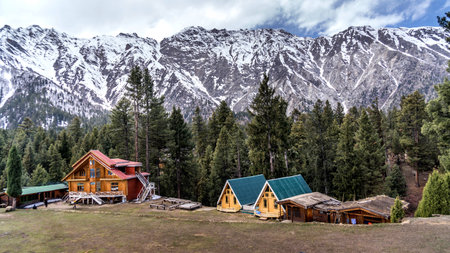 Wooden bungalows on the background of high snowy mountains at Fairy Meadows in Pakistan.の写真素材