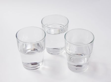 Three glasses of water - one nearly empty, one half full, one almost full の写真素材