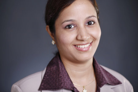 Portrait of an attractive young businesswoman against grey 