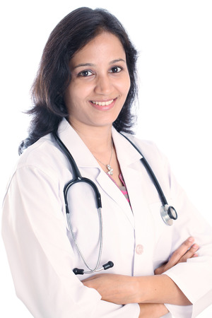Smiling doctor woman with arms crossed against white の写真素材