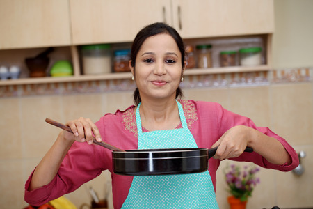 Young woman preparing a dish in her kitchenの写真素材