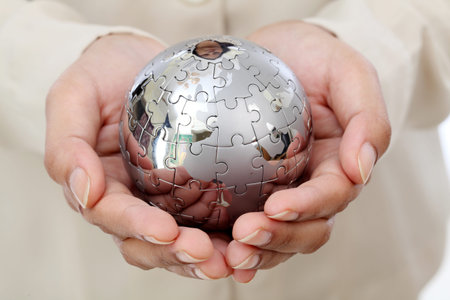 Business woman hand holding jigsaw puzzle globeの写真素材