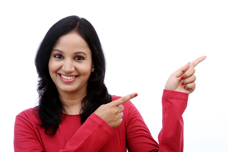 Smiling young woman showing isolated presentation against whiteの写真素材