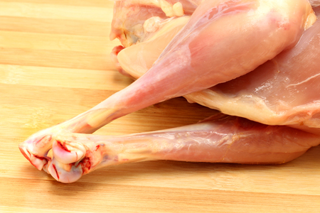 Raw chicken leg on wooden backgroundの写真素材