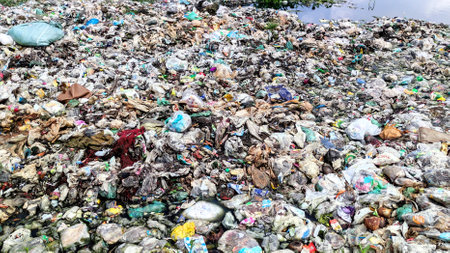 Environmental pollution by dumping different types of garbage in waterの写真素材