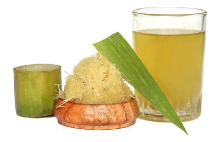 Piece of sugarcane and juice over white backgroundの写真素材