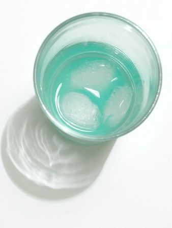 green drink in glass with pieces of iceの写真素材