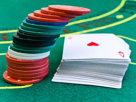 card deck and a few different chips on the playing table in the casino