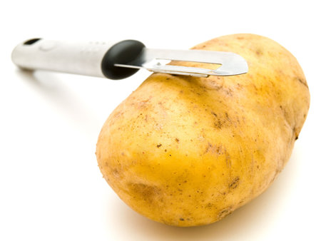 photo of the potato with knife against the white backgroundの写真素材