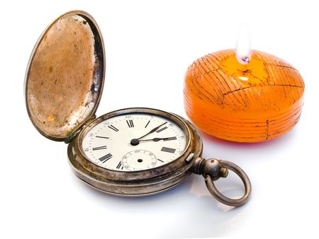 antique silver pocket watches and a burning candle の写真素材